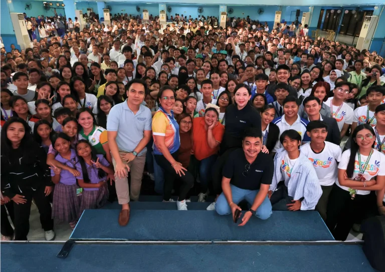 DigiPlus Foundation representatives pose with a packed hall of students at a mental health session in General Santos City