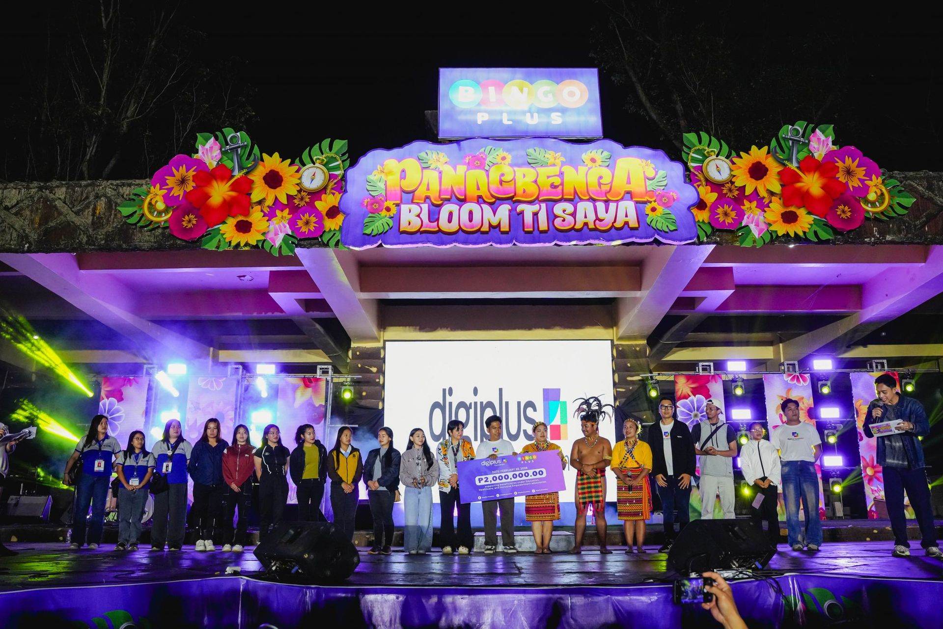 Volunteers and performers in traditional attire hold a ₱2,000,000.00 cheque on the BingoPlus Panagbenga Bloom ti Saya stage